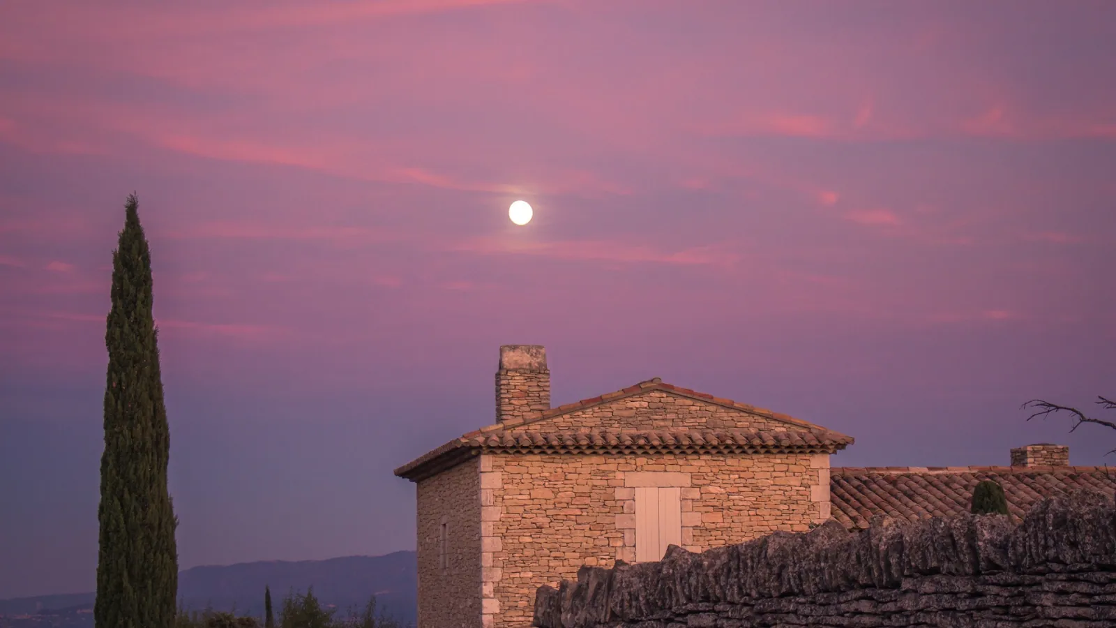Mas en pierre sous un ciel rose, à la tombée de la nuit