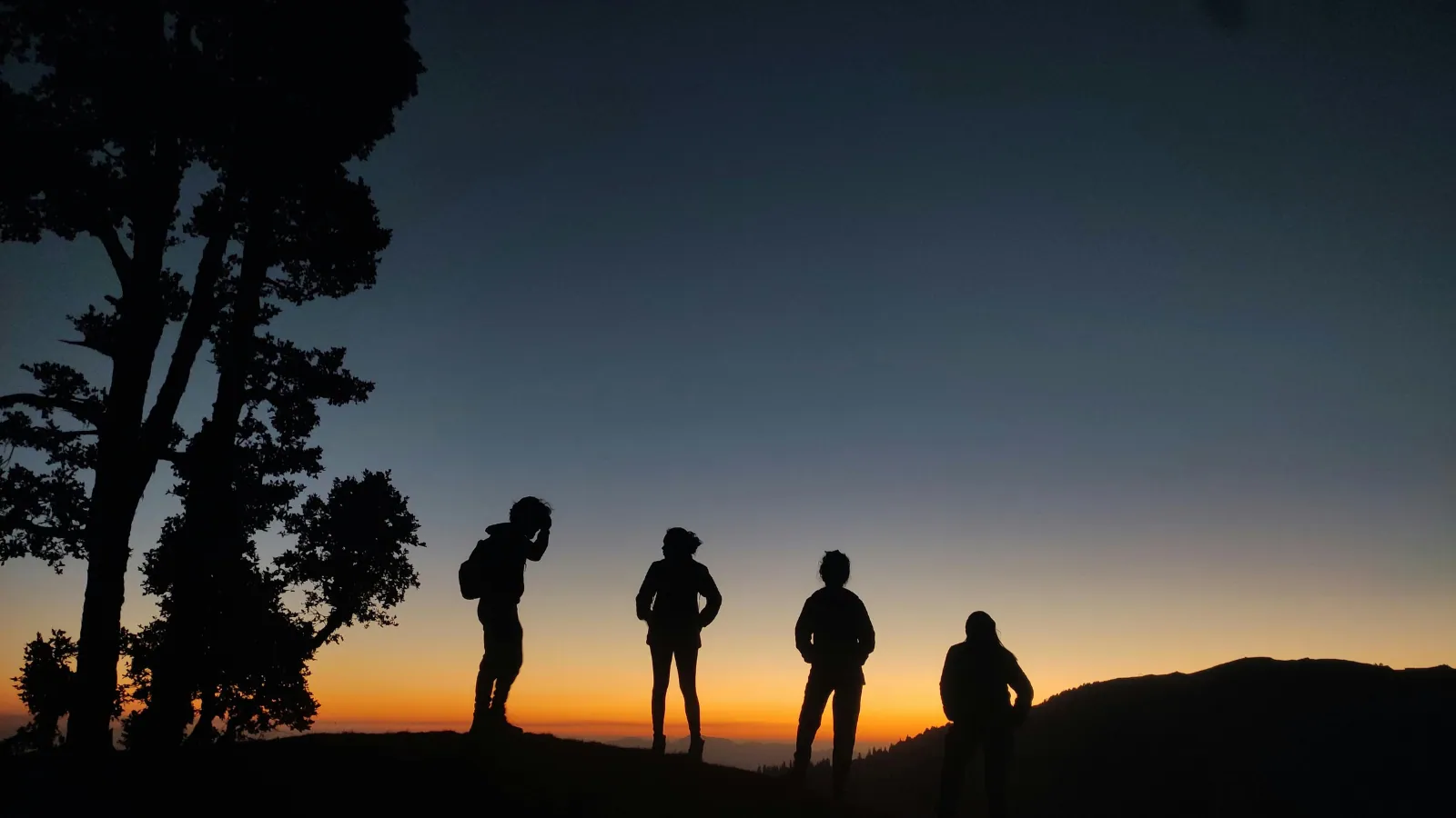Silhouettes de promeneurs au crépuscule sur une crête
